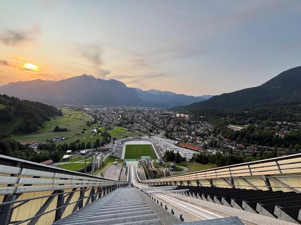Schanzenführung Skisprungschanze Garmisch-Partenkirchen: Sonnenuntergang auf dem Schanzenturm mit Blick über Garmisch-Partenkirchen
