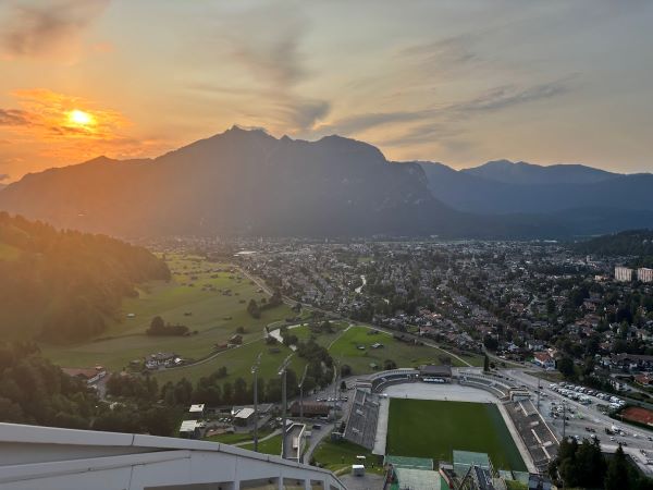 Schanzenführung Skisprungschanze Garmisch-Partenkirchen: Sonnenuntergang auf dem Schanzenturm mit Blick über Garmisch-Partenkirchen